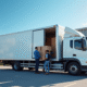 Camion blanc de livraison moderne devant une petite entreprise