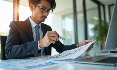 Jeune professionnel en costume analysant des documents financiers