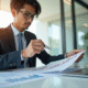 Jeune professionnel en costume analysant des documents financiers